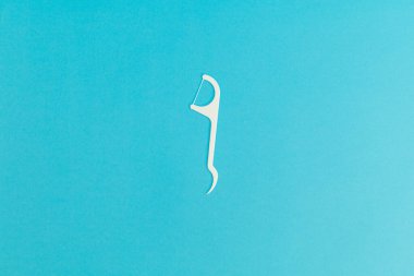 Floss with plastic handle on blue background