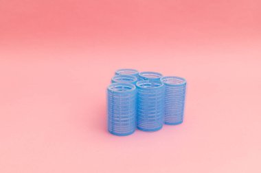 Pembe arka planda mavi saç bigudileri