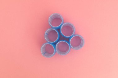 Pembe arka planda mavi saç bigudileri