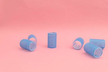 Pembe arka planda mavi saç bigudileri