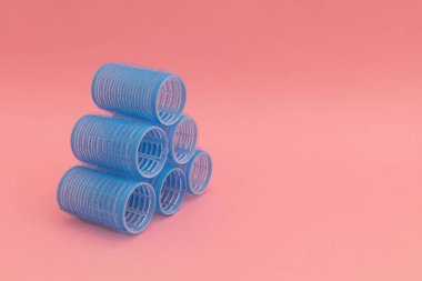 Pembe arka planda mavi saç bigudileri