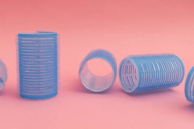 Pembe arka planda mavi saç bigudileri