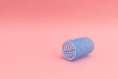 Pembe arka planda mavi saç bigudileri