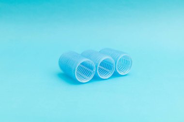 Mavi arka planda büyük saç bigudileri, tek renkli.