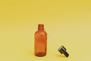 Sarı arka planda serum şişesi