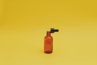 Sarı arka planda serum şişesi