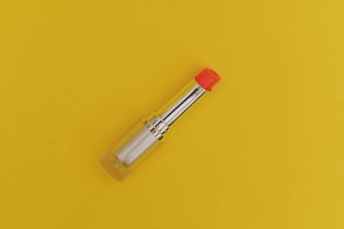 Sarı arka planda parlak yeşil şapkalı ruj.