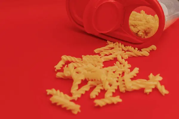 stock image Pasta scattered on a red background