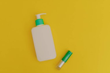 Sarı arka planda beyaz makyaj ve ruj şişesi.