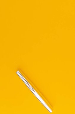 Sarı arka planı olan gümüş rimel.