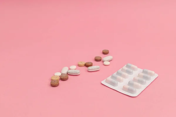 ピンクの背景に丸薬と医学 — ストック写真