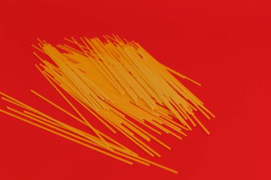 Kırmızı arkaplanda makarna olan kırmızı kavanoz, tek renkli.