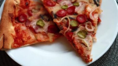 Bir tabakta iki dilim pizza, ağır çekim.