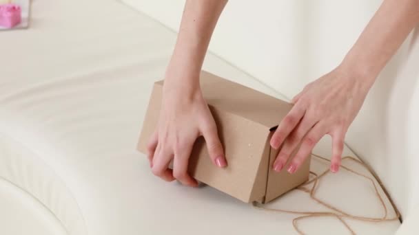 Uma Menina Abre Uma Caixa Papelão Com Presente Com Mão — Vídeo de Stock