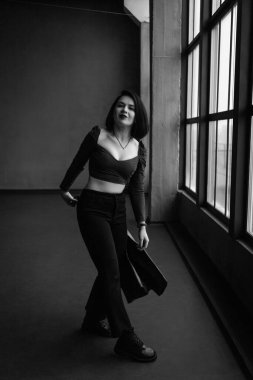 Siyah deri ceketli, siyah saçlı bir kadın.