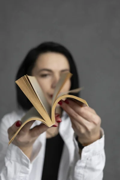 Beyaz Gömlekli Kadın Bir Kitabı Karıştırıyor — Stok fotoğraf