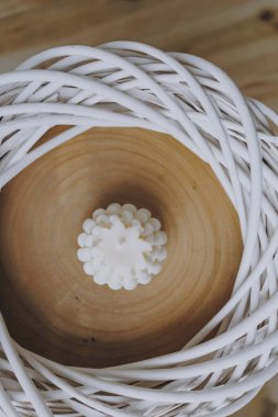 Hasır çerçevenin ortasında beyaz mum