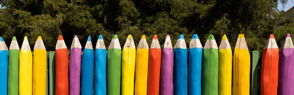 Çitli pankart. Renkli kalemler şeklinde.