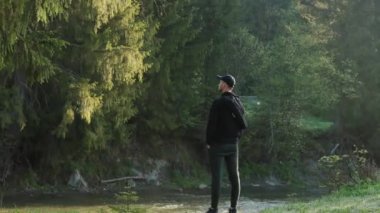 Ormanda dikilen bir adam, ağaçlara hayran.