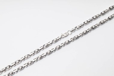 Beyaz arka planda alışılmadık şekilli gümüş zincir, mücevherler