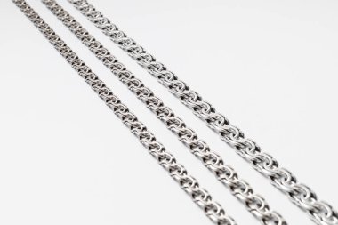 Beyaz arka planda alışılmadık şekilli gümüş zincir, mücevherler