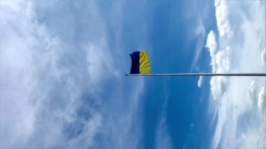 Ukrayna bayrağı mavi gökyüzünün arka planında, ülkenin sembollerinde, sosyal ağlar için dikey videoda gelişir. 