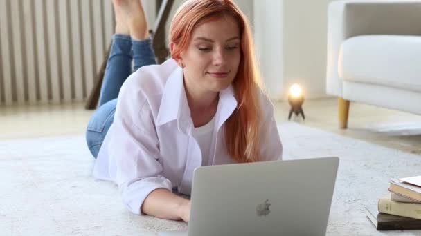 Una Chica Pelo Rojo Yace Suelo Con Una Computadora Portátil — Vídeos de Stock