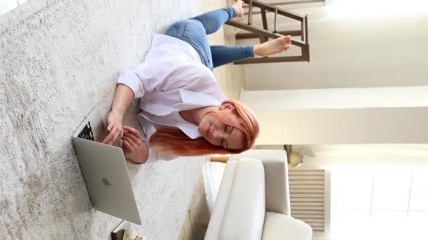 Ένα Κορίτσι Κόκκινα Μαλλιά Κουνάει Πόδια Της Ξαπλωμένη Στο Πάτωμα — Αρχείο Βίντεο
