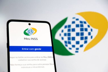 Aplicativo INSS do governo para aposentados no Brasil, na tela de um celular e fundo desfocado.