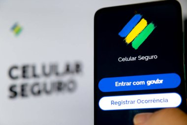 Aplicativo Celular Seguro com fundo desfocado ve core do Brasil.