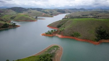 Yukarıdan bakıldığında insansız hava aracı, alçak seviyesi ve doğanın arka planıyla dolu bir baraj..
