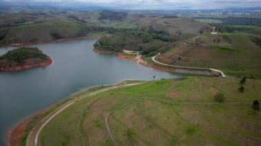 Yukarıdan bakıldığında insansız hava aracı, alçak seviyesi ve doğanın arka planıyla dolu bir baraj..