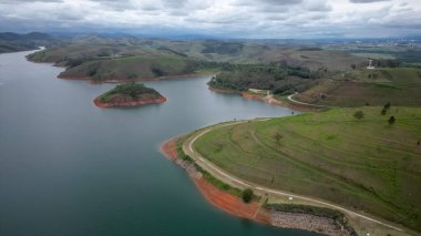 Yukarıdan bakıldığında insansız hava aracı, alçak seviyesi ve doğanın arka planıyla dolu bir baraj..