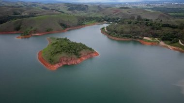 Yukarıdan bakıldığında insansız hava aracı, alçak seviyesi ve doğanın arka planıyla dolu bir baraj..