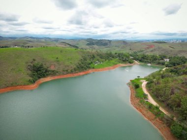 Yukarıdan bakıldığında insansız hava aracı, alçak seviyesi ve doğanın arka planıyla dolu bir baraj..