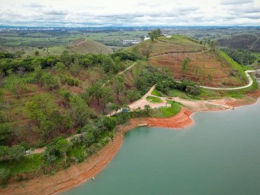 Yukarıdan bakıldığında insansız hava aracı, alçak seviyesi ve doğanın arka planıyla dolu bir baraj..