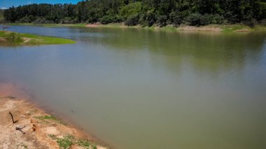 Barajın ve otobanın üstünden yüksek köprüler ve güzel mavi gökyüzü ile çevrili doğa manzarası.