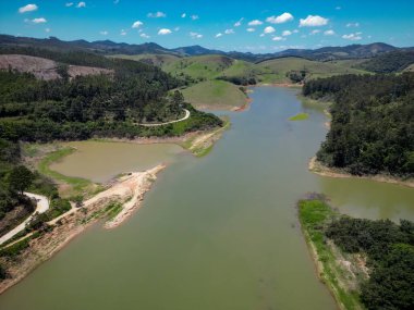 Barajın ve otobanın üstünden yüksek köprüler ve güzel mavi gökyüzü ile çevrili doğa manzarası.
