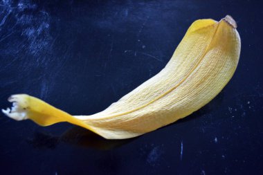 Siyah parlak bir arka planda büyük, kurutulmuş sarı bir orkide yaprağı..