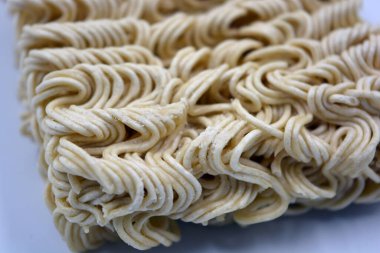 Quick cooking product, food, vermicelli, thin noodles in dry form is located on a white background.
