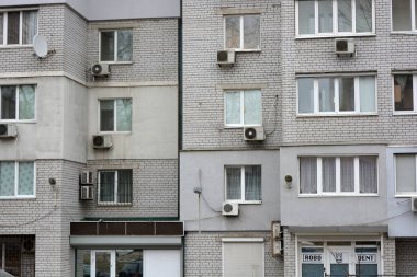 Multi-storey houses made of white, red bricks, a lot of closed balconies and white windows. The house stands in the city of Dnipro, Ukraine.
