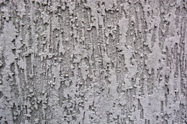 Building backgrounds, wall cladding made with brown textured and structural plaster in the form of bark on the wall of one of the houses in the city of Dnipro, Ukraine.