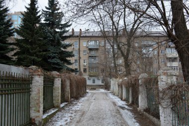 Quiet winter snowy streets, nooks and crannies of the street with houses, high fences in the city of Dnipro, ukraine.