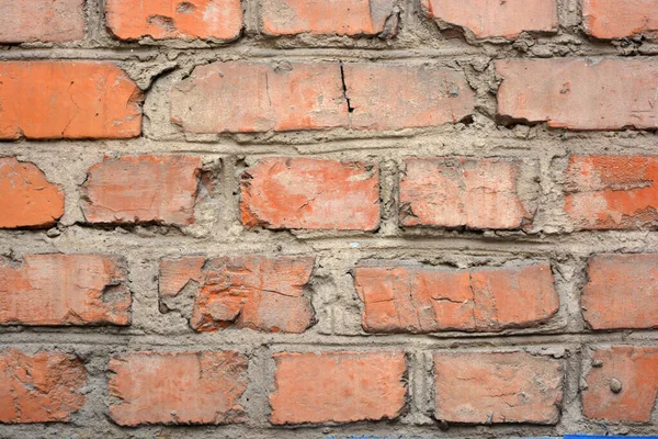 The building wall of one of the houses is built of old, solid red kirpech and reliable cement masonry.