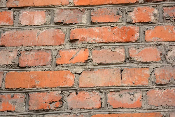 The building wall of one of the houses is built of old, solid red kirpech and reliable cement masonry.