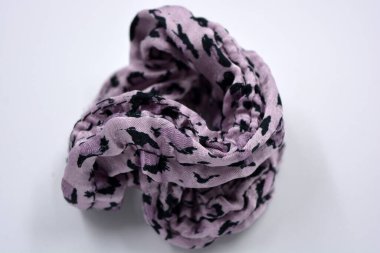 An interesting women's fabric elastic band made of purple with black dots of hair fabric is located on a white background.