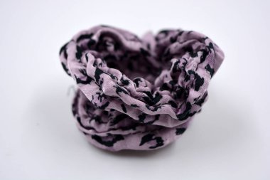 An interesting women's fabric elastic band made of purple with black dots of hair fabric is located on a white background.