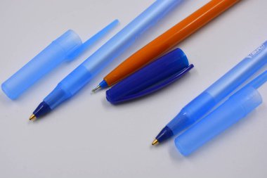 Bright and colorful three open handles made of blue transparent, yellow plastic with caps located on a white background.