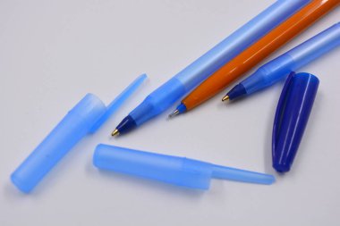 Bright and colorful three open handles made of blue transparent, yellow plastic with caps located on a white background.