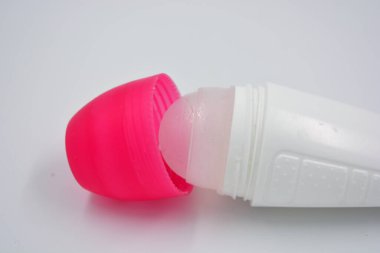 Beyaz arka planda pembe kapaklı kadın deodorantının ilginç bir plastik ambalajı bulunuyor..